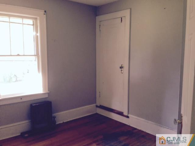 1563 Englishtown Road Old Bridge, NJ 08857 - Photo 4 of 15 a view of an empty room with wooden floor and a window