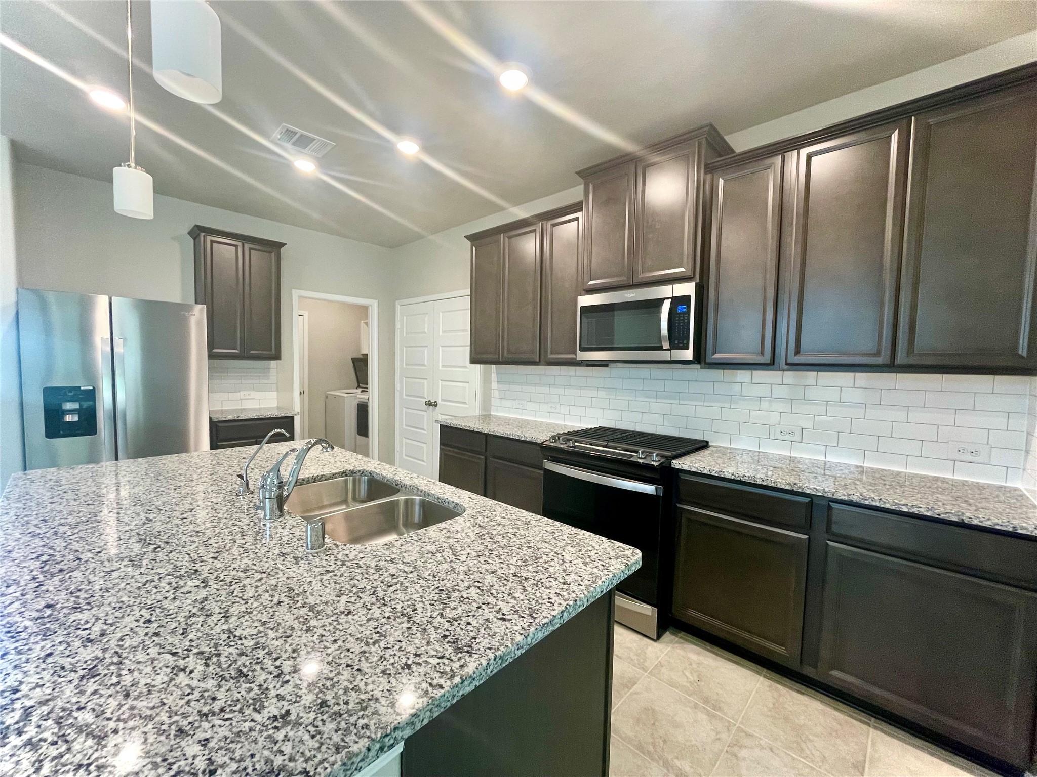 17526 Rosette Grass Conroe, TX 77385 - Photo 11 of 49 a kitchen with stainless steel appliances granite countertop a sink stove and refrigerator