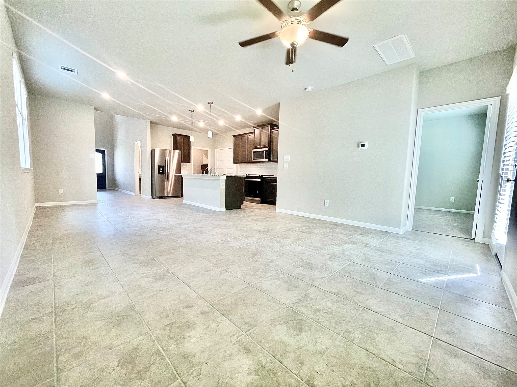 17526 Rosette Grass Conroe, TX 77385 - Photo 12 of 49 a view of a livingroom with a chandelier fan and kitchen view