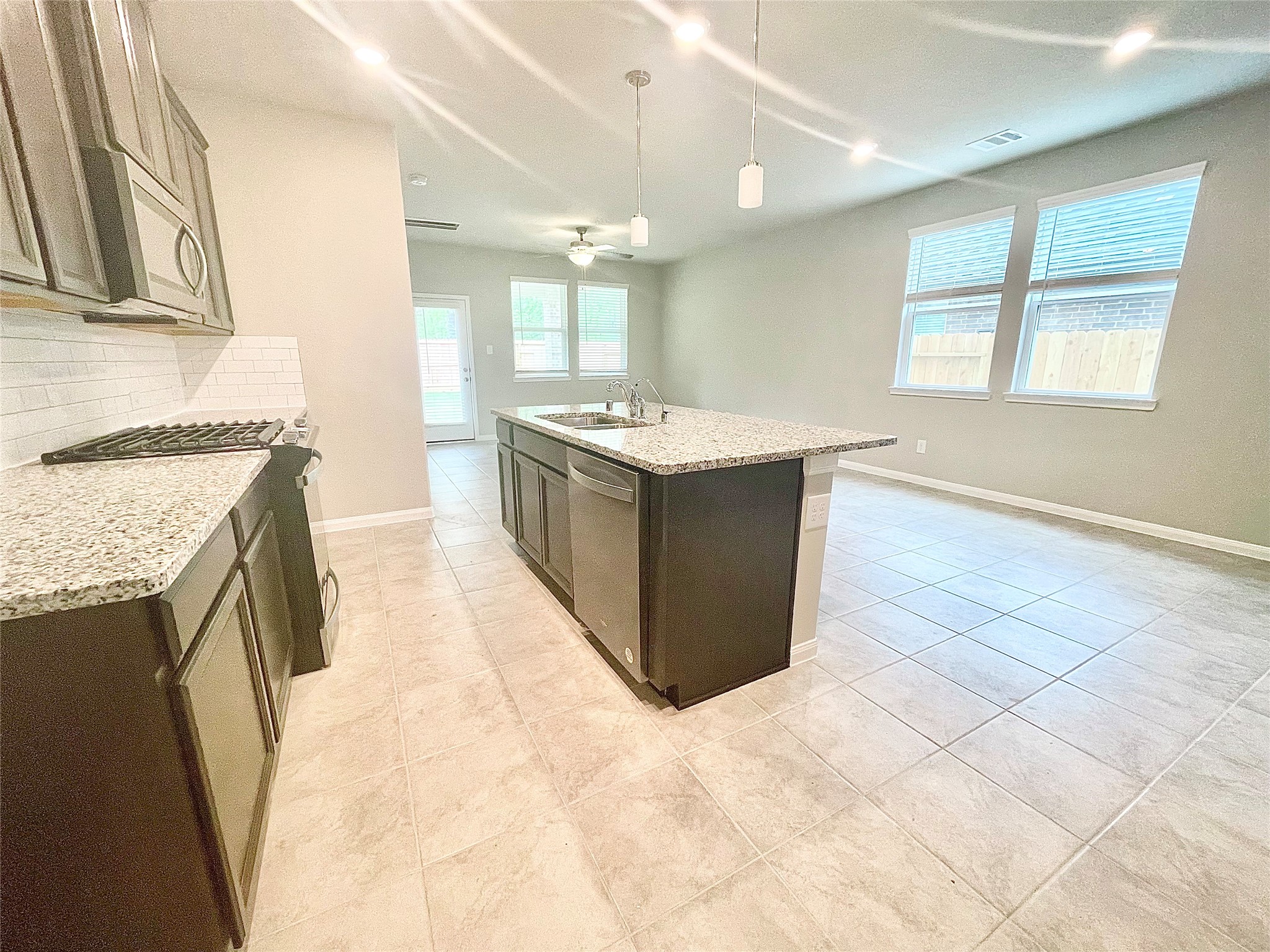 17526 Rosette Grass Conroe, TX 77385 - Photo 13 of 49 a kitchen with granite countertop a sink and a stove top oven