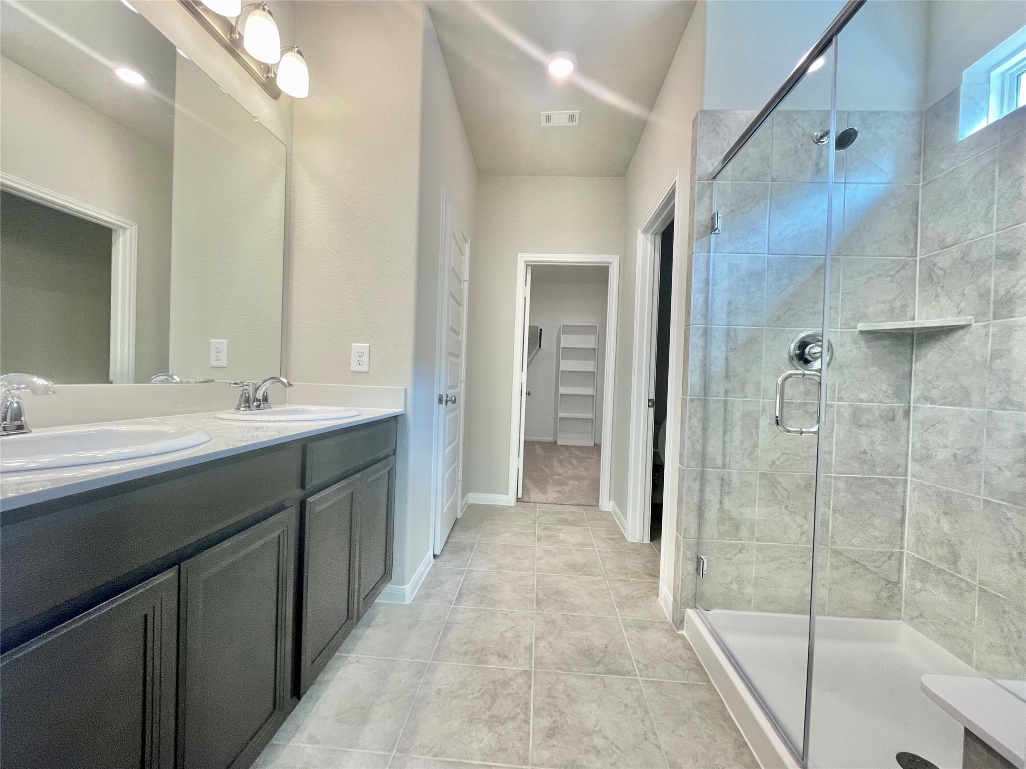 17526 Rosette Grass Conroe, TX 77385 - Photo 16 of 49 a bathroom with a double vanity sink mirror and shower