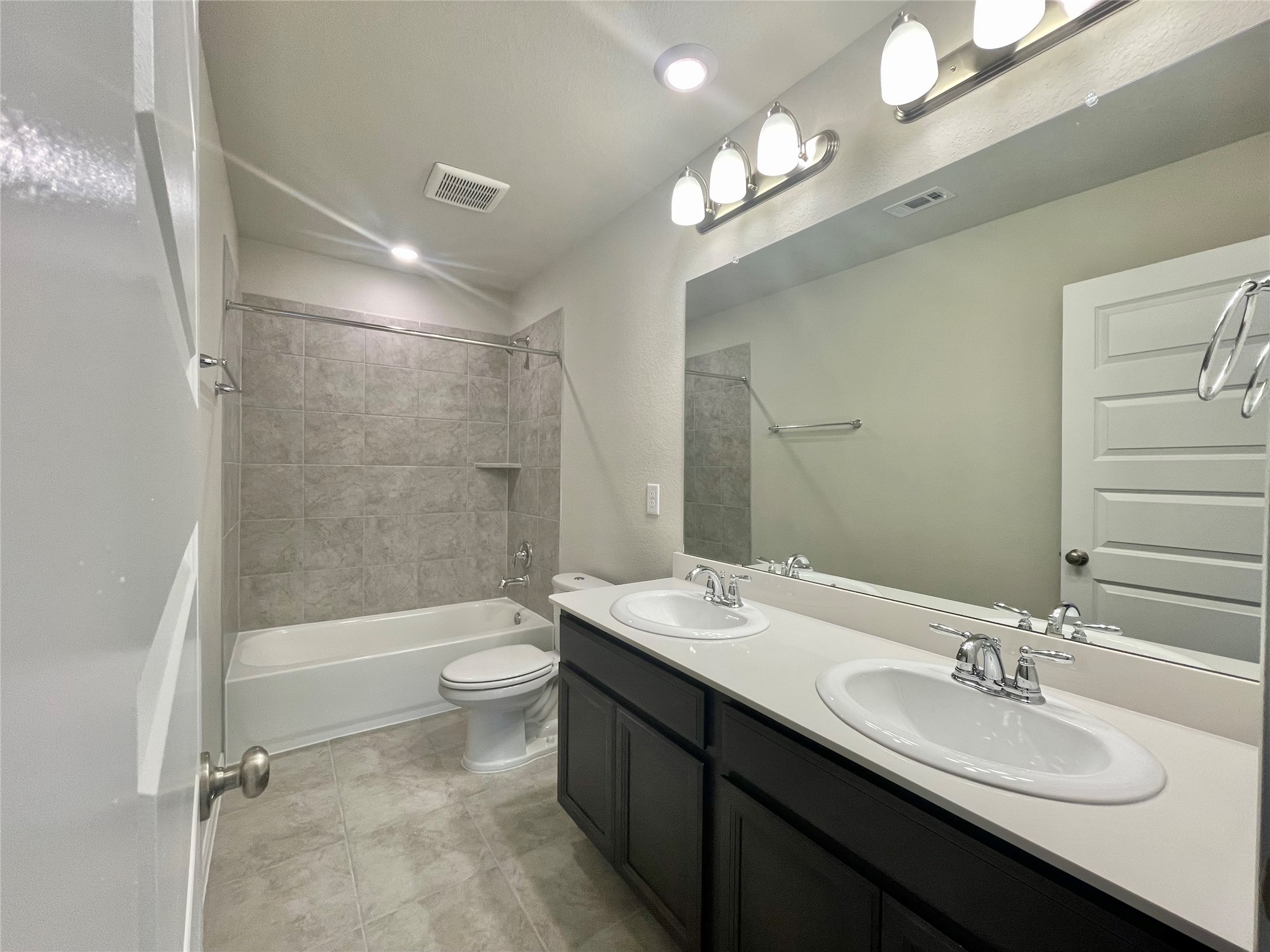 17526 Rosette Grass Conroe, TX 77385 - Photo 31 of 49 a bathroom with a double vanity sink toilet mirror and bathtub