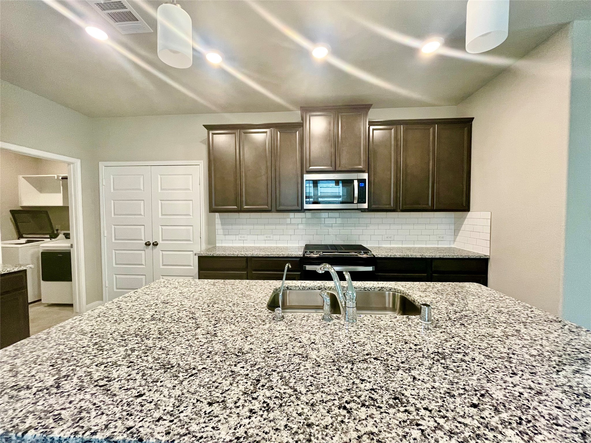 17526 Rosette Grass Conroe, TX 77385 - Photo 9 of 49 a kitchen with a stove a sink and a refrigerator