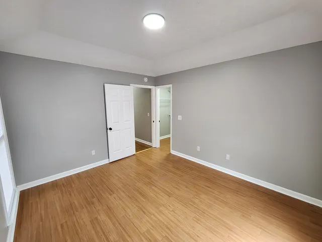 a view of an empty room with wooden floor