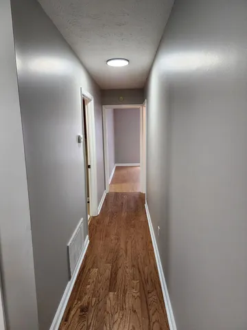 a view of a hallway with wooden floor
