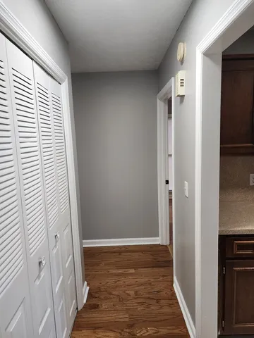 a view of a hallway with wooden floor and staircase