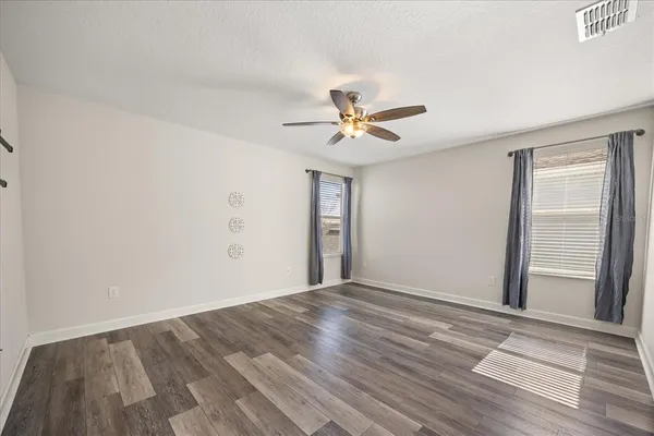 a view of empty room with wooden floor
