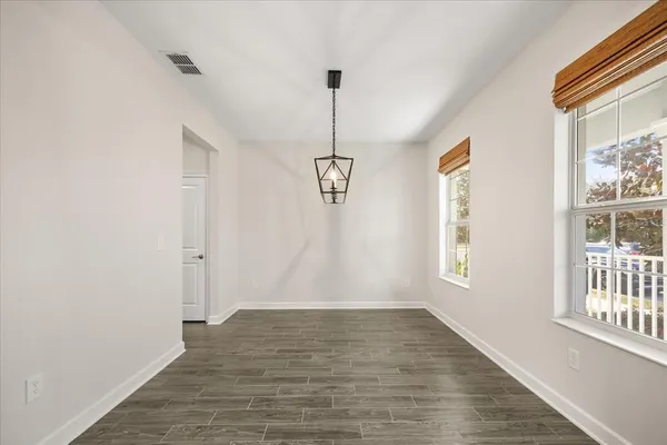 a large kitchen with cabinets wooden floor and stainless steel appliances
