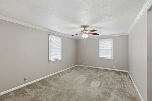 a view of an empty room with a chandelier fan
