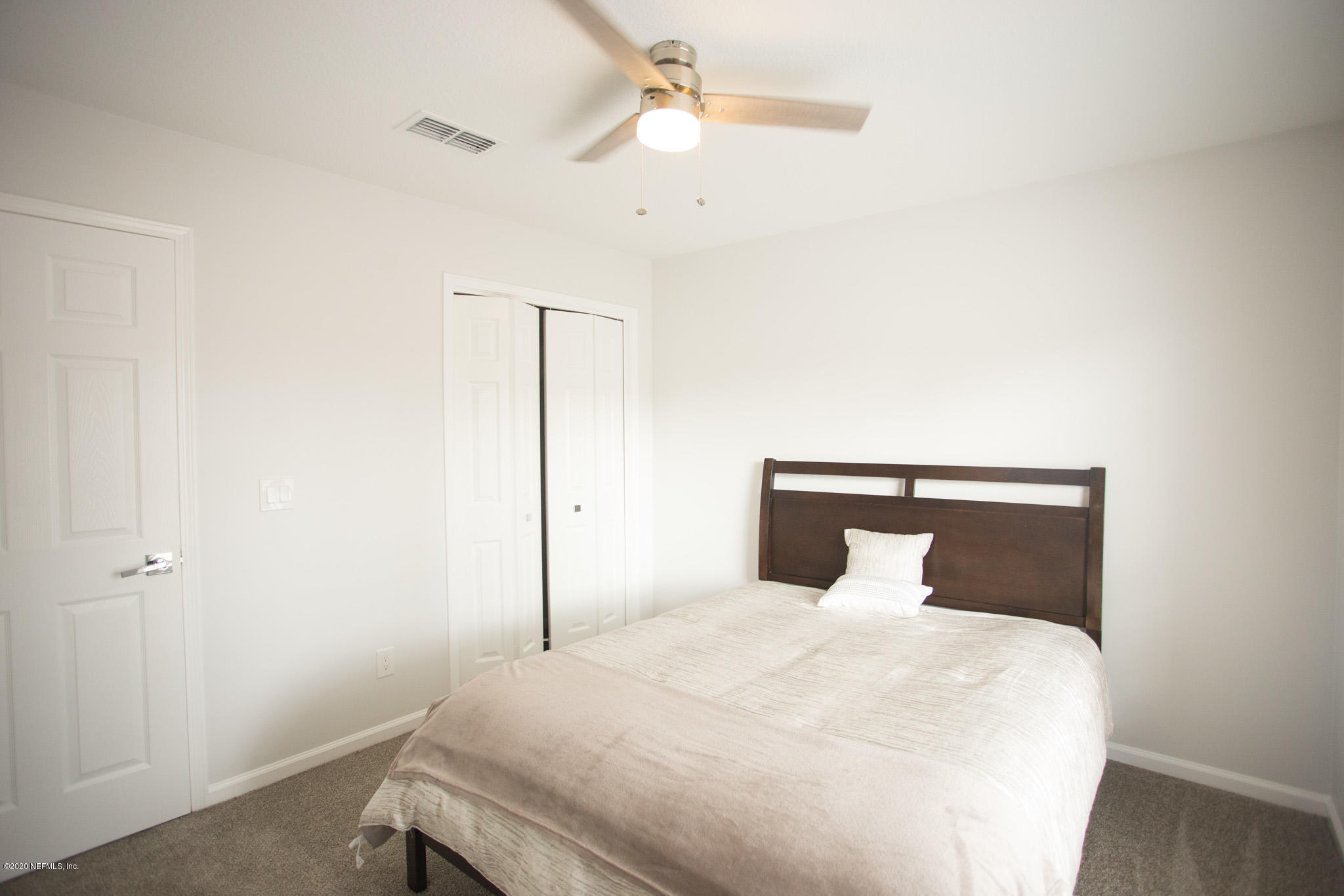 7864 Collins Ridge Boulevard Jacksonville, FL 32244 - Photo 3 of 32 a bedroom with a bed and a ceiling fan