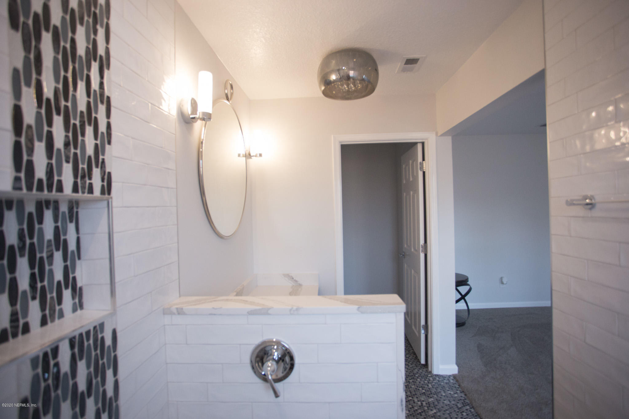 7864 Collins Ridge Boulevard Jacksonville, FL 32244 - Photo 10 of 32 a bathroom with a granite countertop sink a mirror and shower
