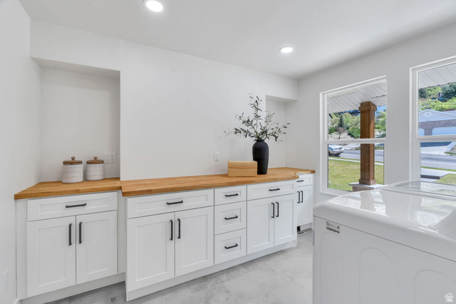 3813 North Foothill Drive Provo, UT 84604 - Photo 19 of 71 Bright utility space featuring dual windows, recessed lighting, wood-finish countertops, white cabinetry with black hardware, and an appliance bay
