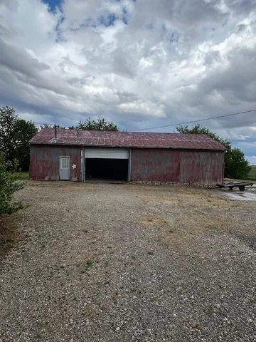 a view of a house with a dry yard and wooden fence