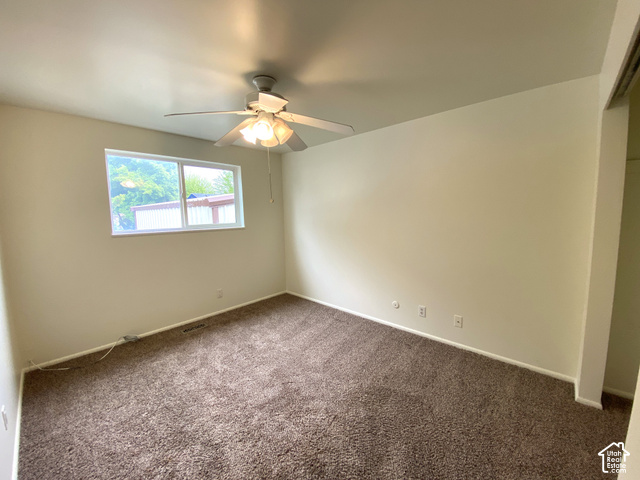 2989 Rae Street West Valley City, UT 84120 - Photo 12 of 25 Neutral wall paint, brown carpet flooring, ceiling fan with integrated lighting, and a double-pane window