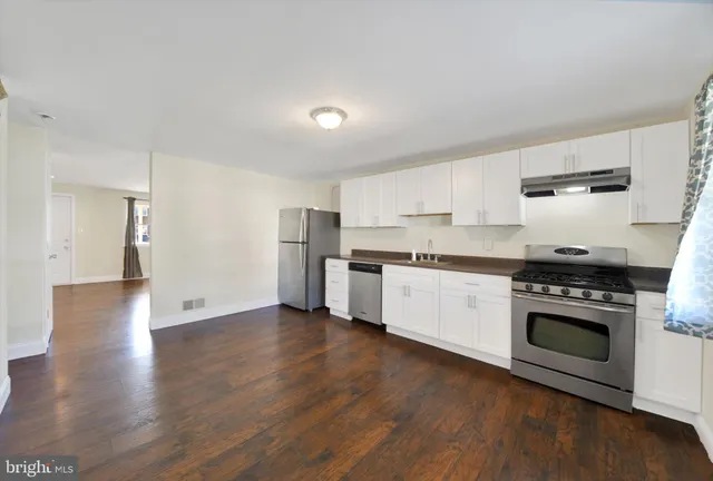 a kitchen with stainless steel appliances white cabinets and a fireplace