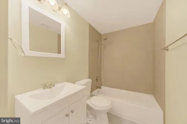 a bathroom with a sink and mirror with toilet