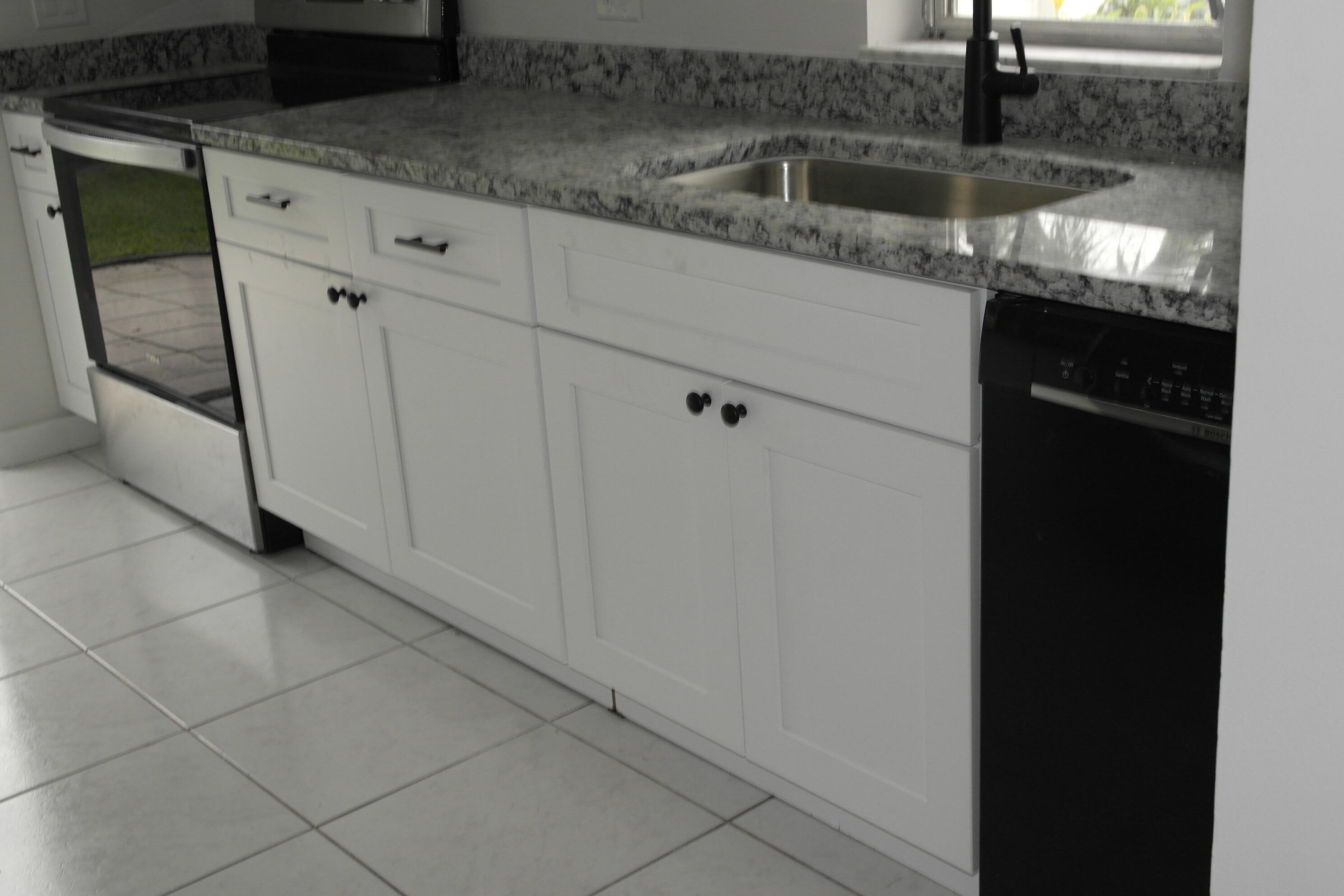 18890 Candlewick Drive, Unit B Boca Raton, FL 33496 - Photo 2 of 16 a kitchen with granite countertop a sink and a stove