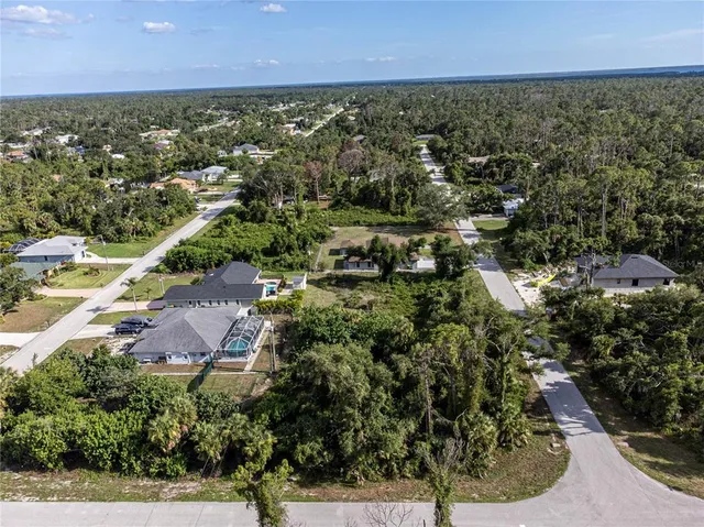 an aerial view of residential houses with outdoor space and trees