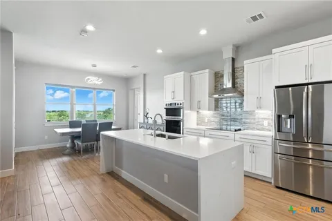 a kitchen with a sink stainless steel appliances a window and a counter top space