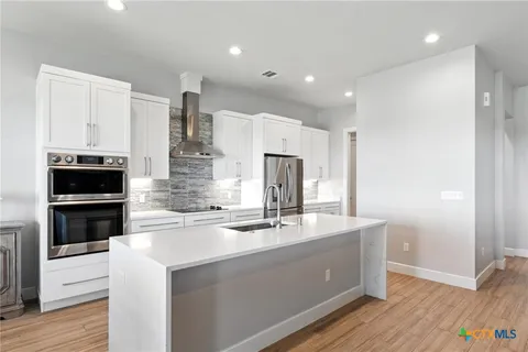 a kitchen with kitchen island stainless steel appliances a sink and stove