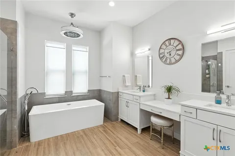 a spacious bathroom with a double vanity sink and a bathtub