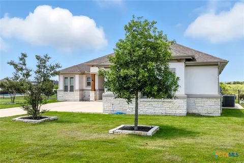 a front view of a house with a yard fire pit and a fountain