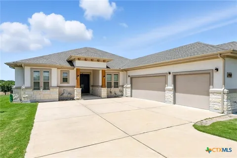a front view of a house with a garden and mountain view