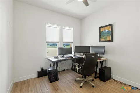 a view of a workspace with furniture and a window