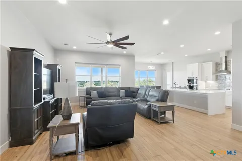 a living room with furniture kitchen view and a refrigerator