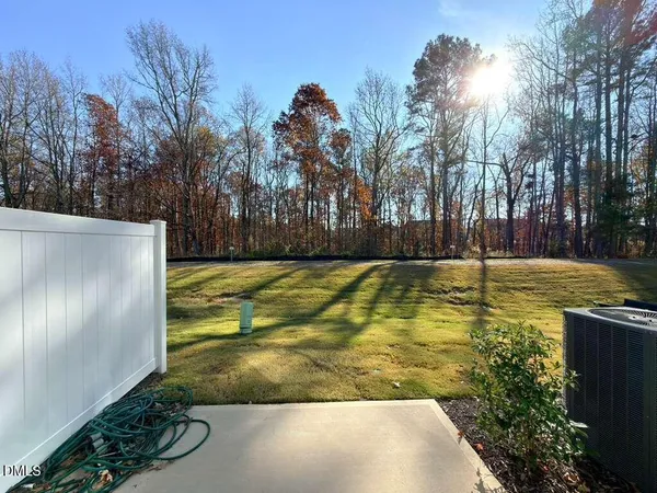 a view of a house with potted plants and a table and chairs