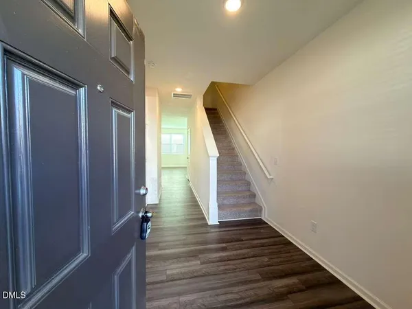 a view of a hallway with wooden floor and staircase