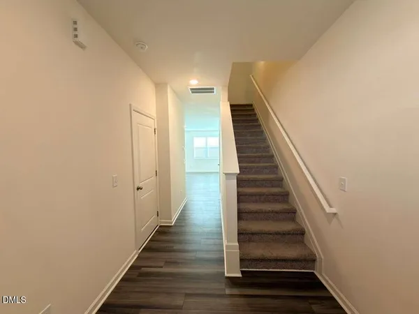 a view of a hallway with wooden floor and entryway