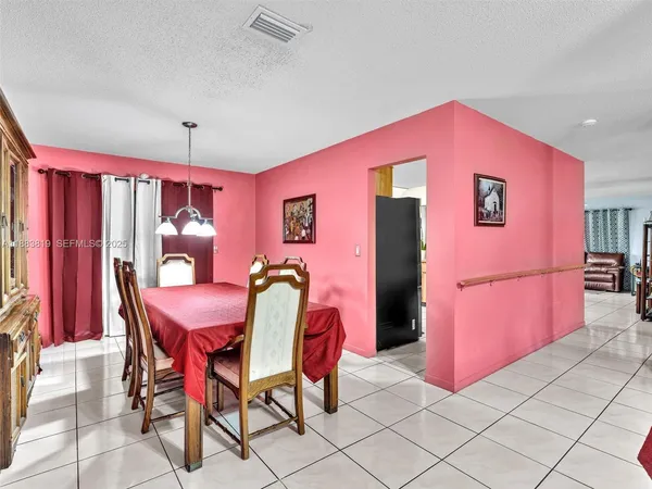 a dining room with furniture and a chandelier fan