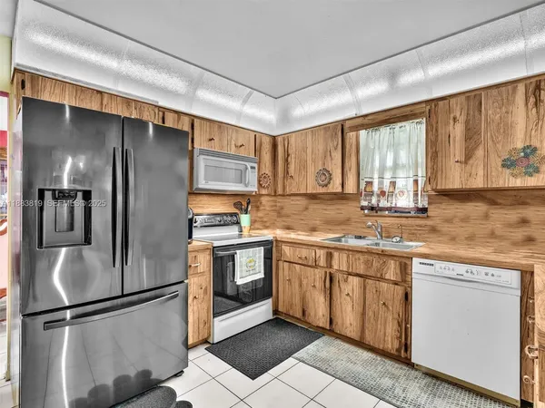 a kitchen with stainless steel appliances granite countertop a refrigerator sink and cabinets