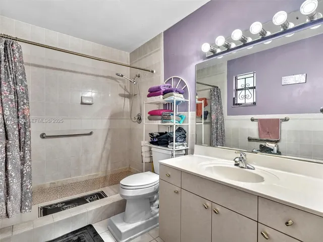 a bathroom with a sink a toilet a shower and a mirror