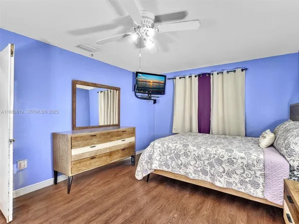 a bedroom with a bed and a ceiling fan
