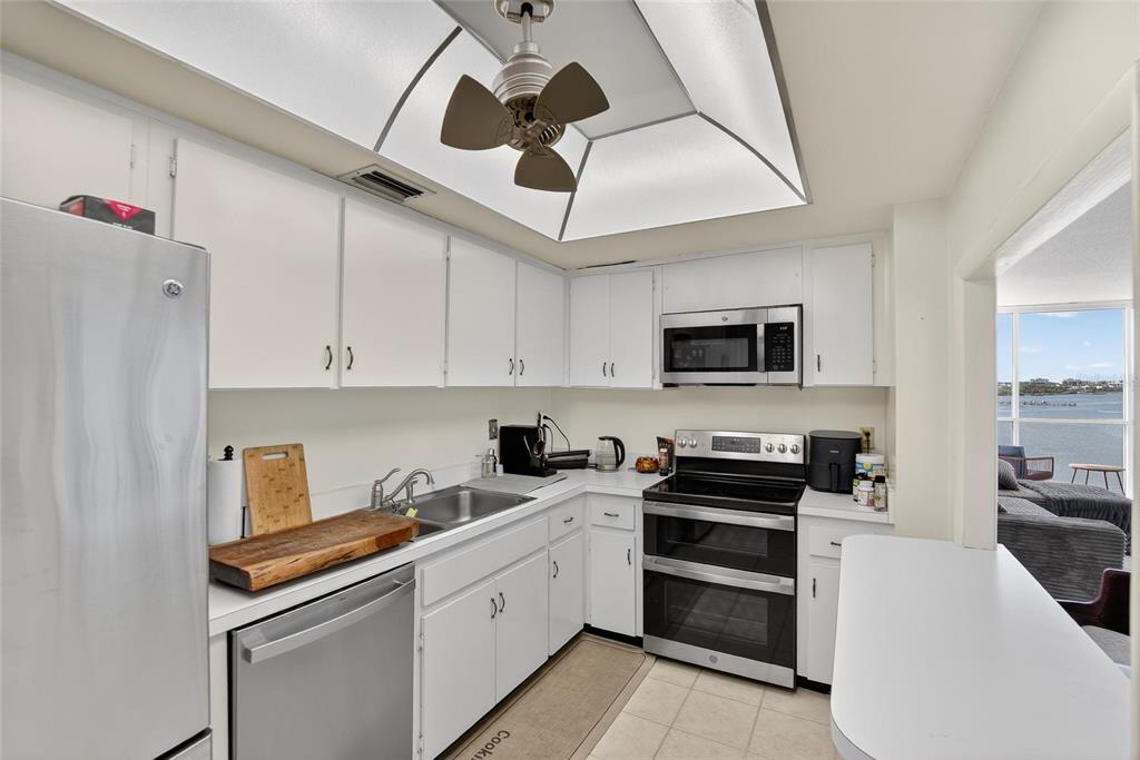 100 Pierce Street, Unit 703 Clearwater, FL 33756 - Photo 13 of 70 a kitchen with stainless steel appliances a microwave a stove and white cabinets