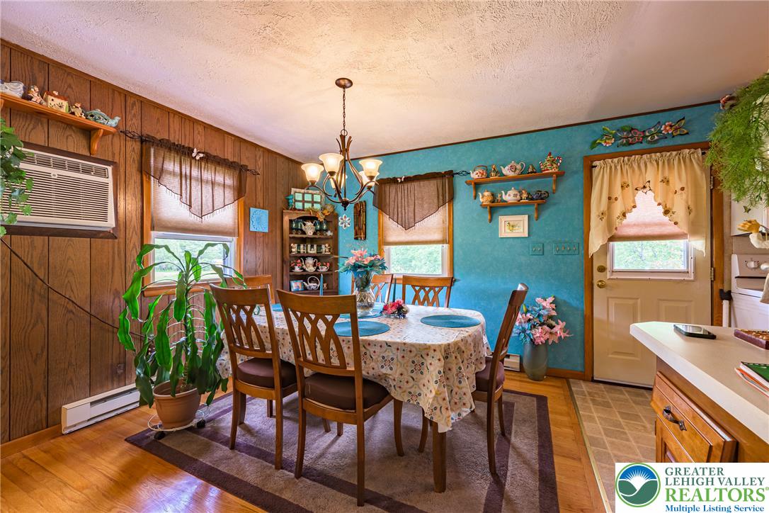 678 Interchange Road Kresgeville, PA 18333 - Photo 16 of 45 Warm wood paneling and vibrant blue walls create an inviting atmosphere in this distinct dining area.