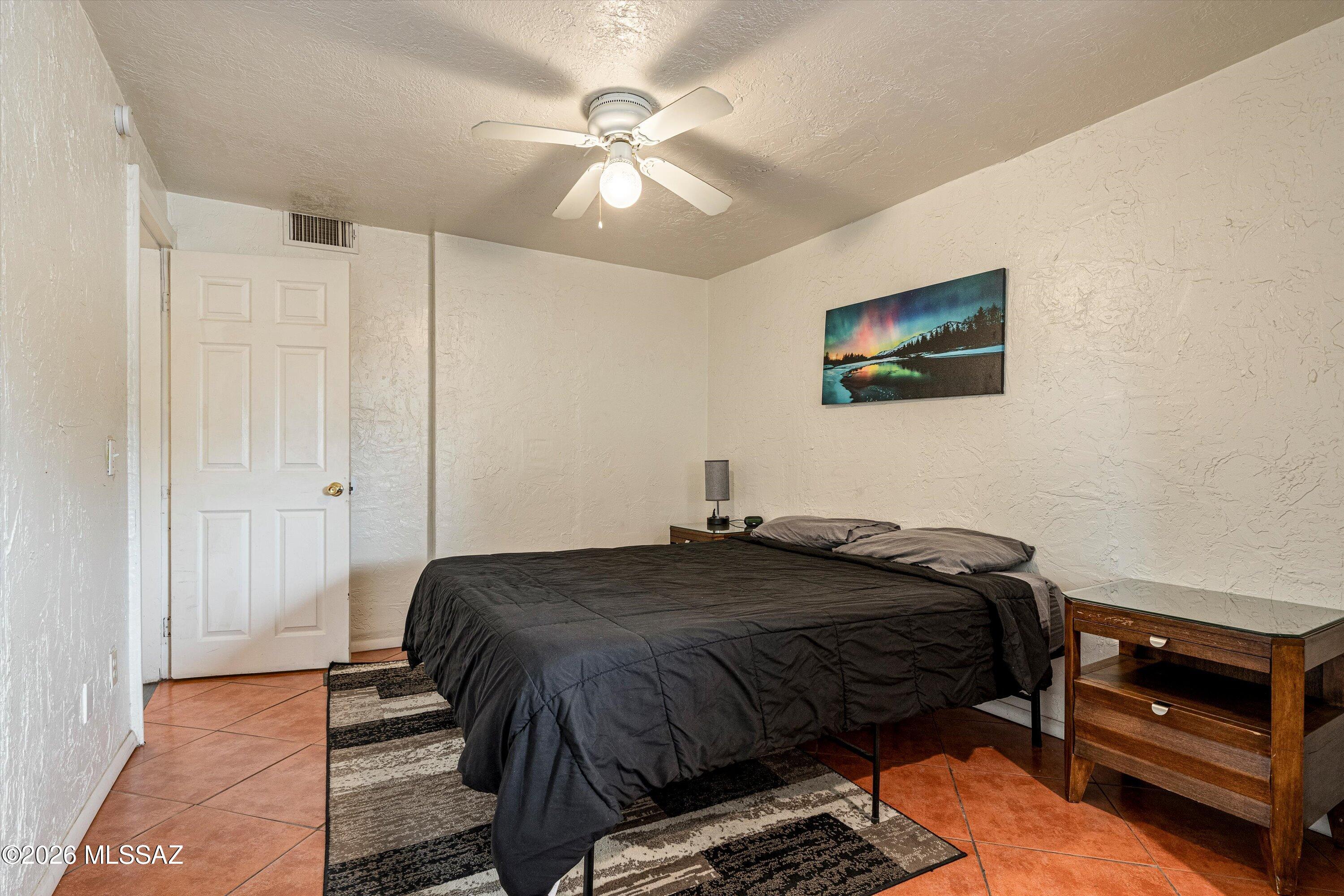 2619 East Prince Road Tucson, AZ 85716 - Photo 24 of 50 a bedroom with a bed and a chandelier