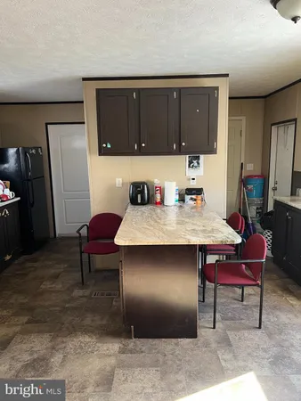 a kitchen with a table chairs and refrigerator