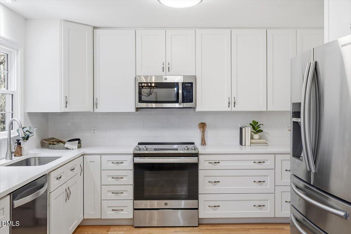 2828 McDowell Road Durham, NC 27705 - Photo 10 of 45 a kitchen with stainless steel appliances white cabinets and a refrigerator