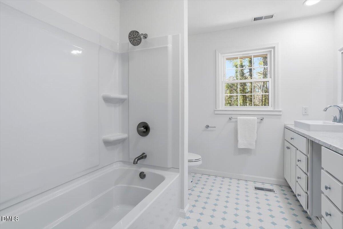2828 McDowell Road Durham, NC 27705 - Photo 31 of 45 a bathroom with a granite countertop sink a toilet and shower