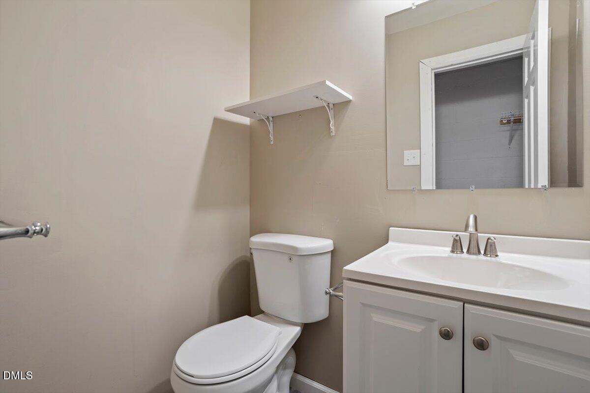 2828 McDowell Road Durham, NC 27705 - Photo 36 of 45 a bathroom with a toilet sink vanity and mirror