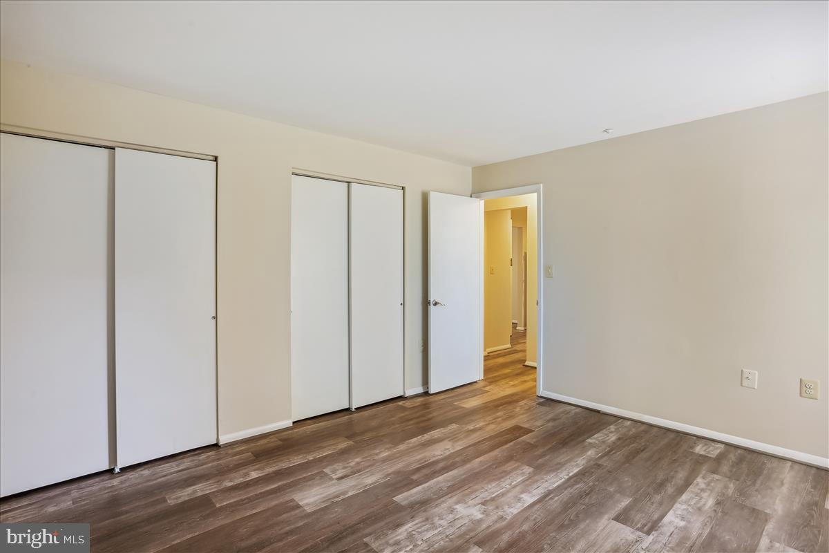 18401 Guildberry Drive, Unit 104 Gaithersburg, MD 20879 - Photo 18 of 24 a view of an empty room with wooden floor and a window