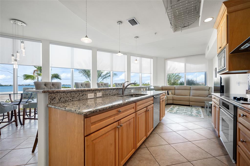 1375 Beach Road, Unit 112 Englewood, FL 34223 - Photo 23 of 50 a kitchen with stainless steel appliances granite countertop a stove a sink and a refrigerator
