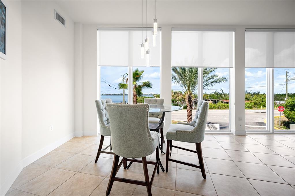1375 Beach Road, Unit 112 Englewood, FL 34223 - Photo 28 of 50 a dining room with furniture a potted plant and a large window