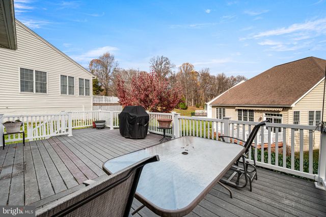 a view of a roof deck with table and chairs with wooden floor and fence