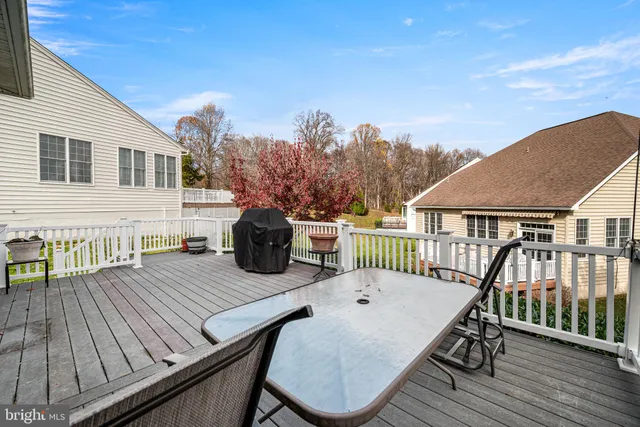 a view of a roof deck with table and chairs with wooden floor and fence