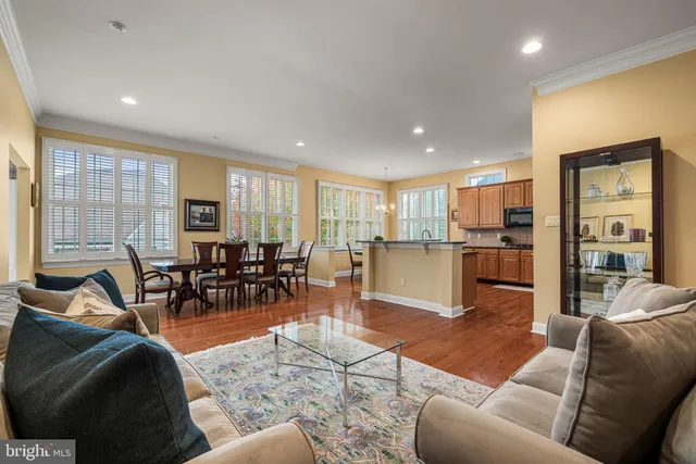 a living room kitchen with furniture and wooden floor