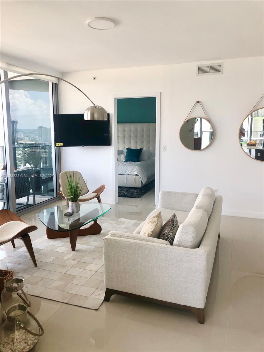 Edgewater Miami, FL 33132 - Photo 3 of 34 a living room with furniture and a flat screen tv
